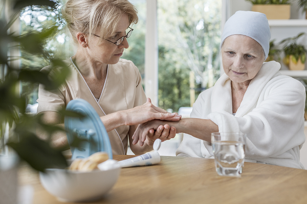 Healthcare worker holding the hand of a terminally ill paitent 